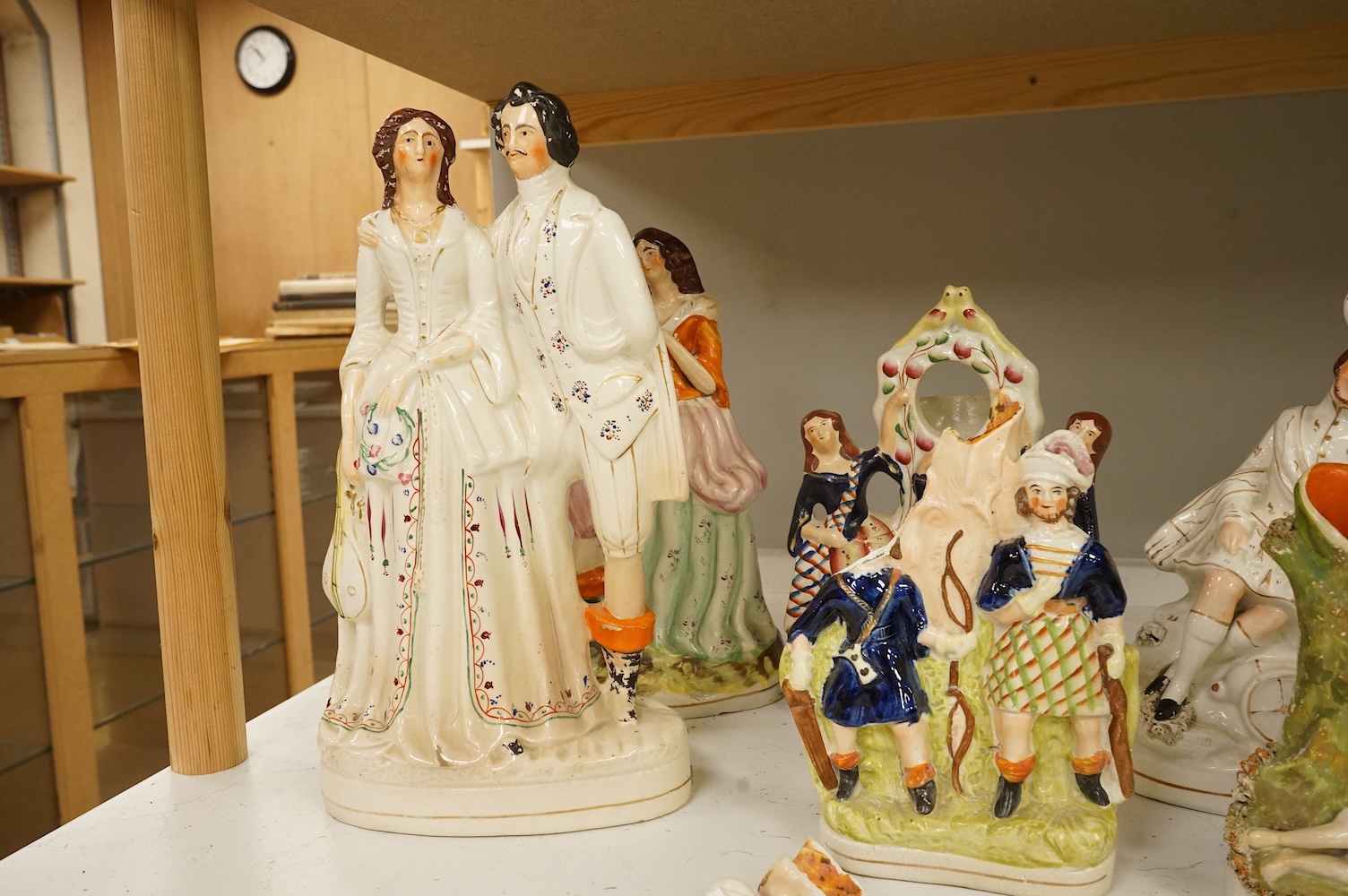 A collection of Staffordshire figures, mostly flatback to include a pocket watch holder, largest 37cm high